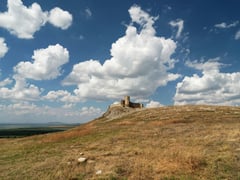 Mănăstire din Dobrogea între dealuri joase și drum de țară